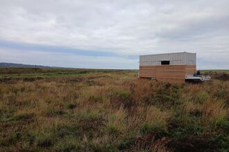 A wood and metal wildlife hide at Cley Marshes.
