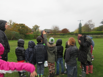 A group of children wearing winter coats in their school grounds, playing a game