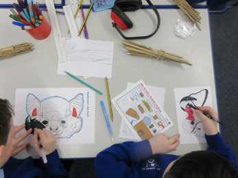Schoolchildren pictured from above as they colour some animal pictures