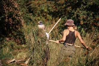 Volunteers raking on a sunny day at Sweet Briar Marshes