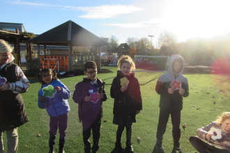 A group of children wearing winter coats in their school grounds, playing a game