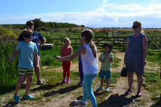 A group of children together with adults playing games on a reserve