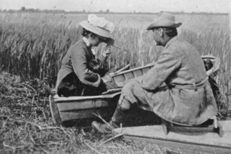 A woman in Edwardian clothes watches nature at Hickling Broad