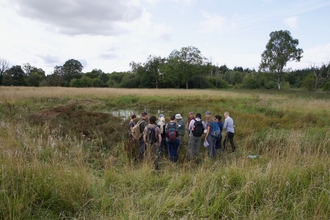A group gather around an excavated pingo pond. 