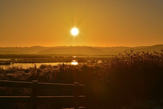 Beautiful golden sunrise over NWT Cley Marshes lagoons