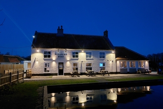 a view of the Pleasure Boat inn at night with the reflection in the water