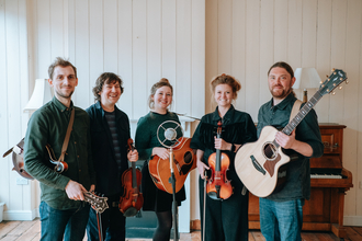 The five members of Kitewing facing the camera and holding their musical iunstruments