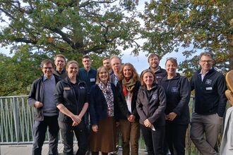 A group of smiling RSPB, NWT and SWT staff at Carlton Marshes. 