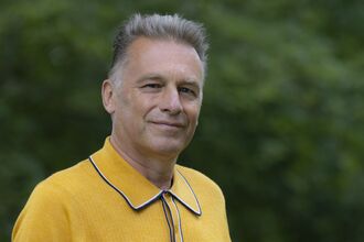 Chris Packham wearing a yellow top and facing the camera