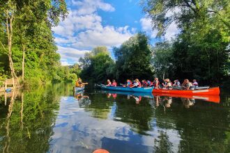 Two canoes sail down a picturesque river