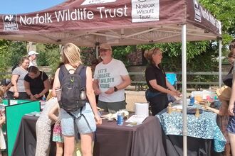 An NWT marquee with people engaging with volunteers and staff at the tables