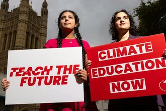 two young women holding up campaign signs