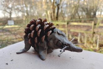 a crafted hedgehog made from clay and a pine cone