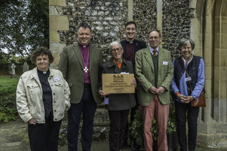 Churchyard Conseration Award winners posing outside a church.
