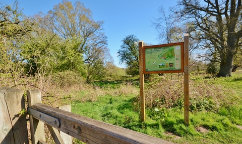 A sign for NWT Hoe Rough standing in a field on a sunny day