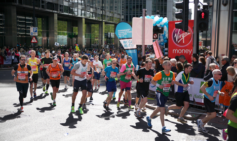 Runners on a sunny day in Canary Wharf take part in the London Marathon