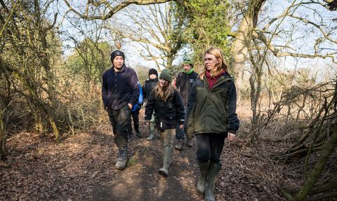A group of young people walking with reserve manager, Matt, at Sweet Briar.