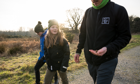 A member of staff walking at Sweet Briar with two kids.