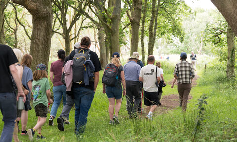 a group of people walking through a wooded area