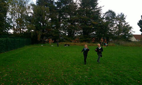 Primary school children playing in a field. 