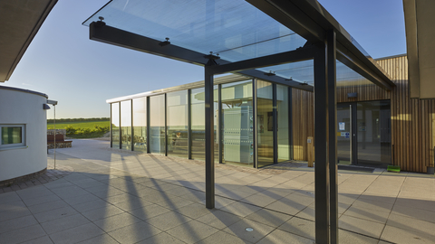 The outside of a glass building and courtyard on a sunny day