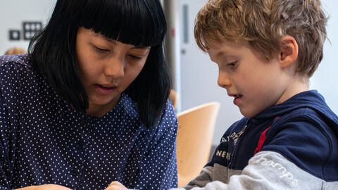 Alice Lee helping a child make a mobile