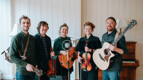 The five members of Kitewing facing the camera and holding their musical iunstruments