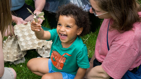 A child smiles and laughs during a moth trapping session