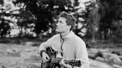 Monochrome picture of Merlyn Driver playing his guitar.