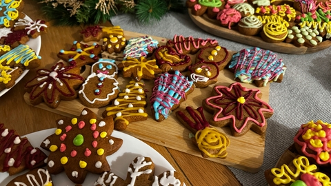 a selection of iced biscuits cut into Christmas shapes on wooden boards on a table