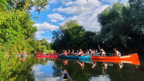 Two canoes sail down a picturesque river
