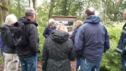 A group of people wearing waterproof coats on a guided walk at Hoe Common