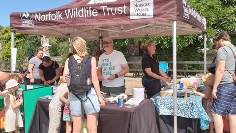 An NWT marquee with people engaging with volunteers and staff at the tables
