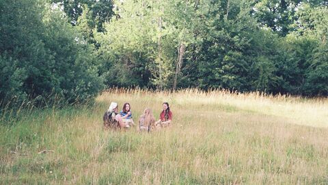 a group of young people sitting in a field