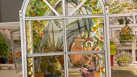 An image of a poo-up paper greenhouse with plants an pots inside