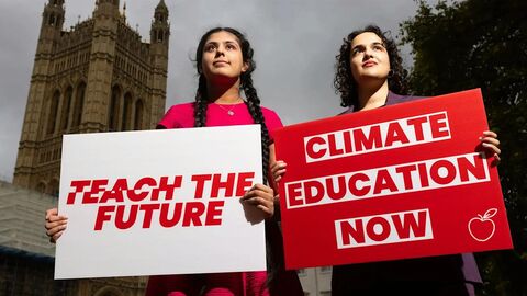 two young women holding up campaign signs