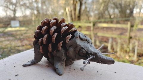 a crafted hedgehog made from clay and a pine cone