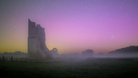 A photo at night of ruins with photography special effects creating a pink sky