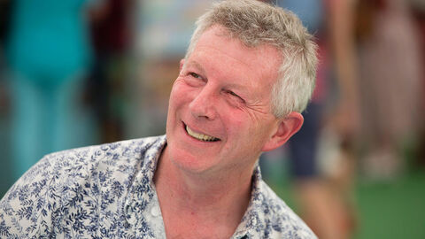 An informal photo of Stephen wearing a patterned shirt and smiling