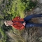 Oscar is wearing a red jacket and blue jeans. He is sitting on a the edge of a dune with binoculars around his neck.