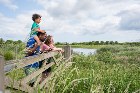 a family standing by a gate looking over Hickling Broad