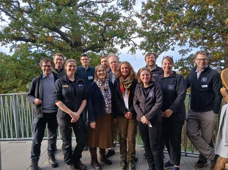 A group of smiling RSPB, NWT and SWT staff at Carlton Marshes. 