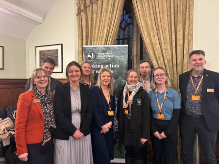 A group of professionals at a parliamentary reception smiling at the camera