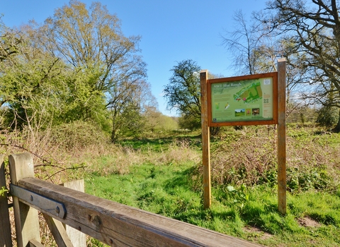 A sign for NWT Hoe Rough standing in a field on a sunny day