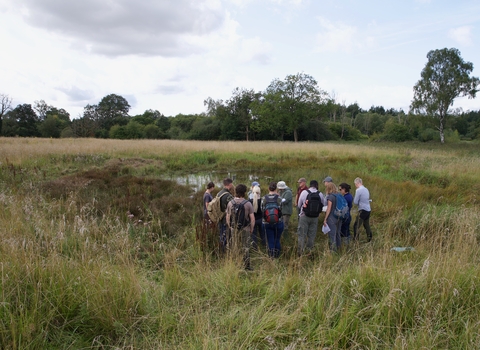 A group gather around an excavated pingo pond.
