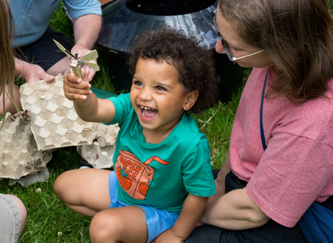 A child smiles and laughs during a moth trapping session