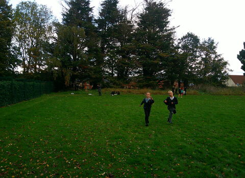 Primary school children playing in a field. 