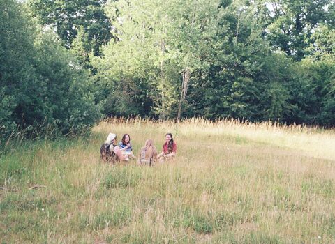 a group of young people sitting in a field